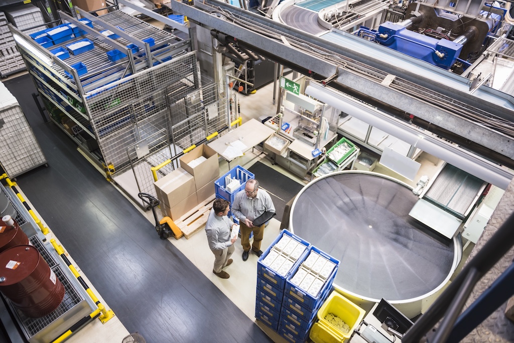 Top view of two men talking in factory shop floor